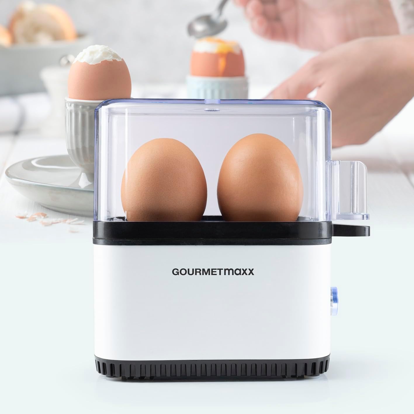 GOURMETmaxx Egg Cooker in use, with a hand reaching for an egg cup