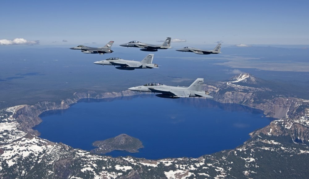 A five ship formation of two F-15 Eagles two F-18 Super Hornets and an F-16 Fighting Falcon fly over Crater Lake Oregon during the Sentry Eagle Excercise Poster Print (18 x 10)
