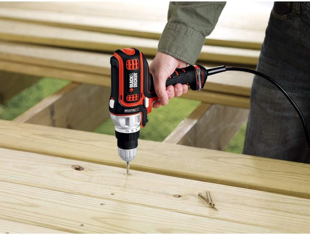 Person drilling into a wooden board with the BLACK+DECKER BDEDMT drill