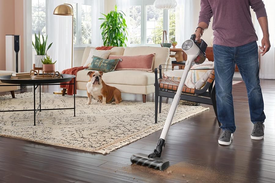 Home aspirant una catifa amb l'aspiradora de mà LG CordZero