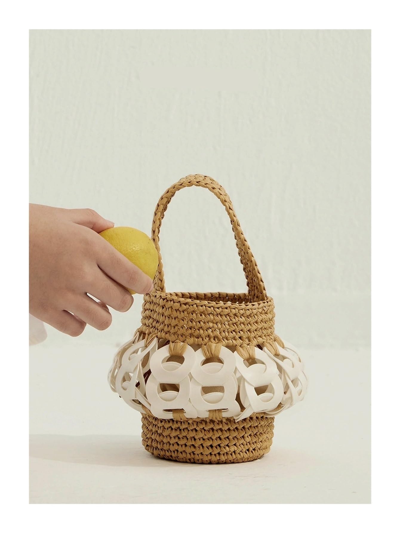 Borsa a secchiello in paglia intrecciata con intricati ritagli