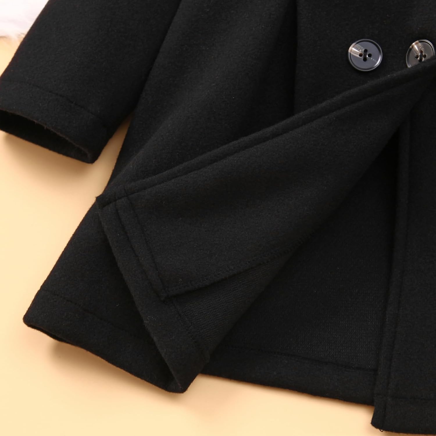 Detail Shot of Black Double-Breasted Baby Coat Hem