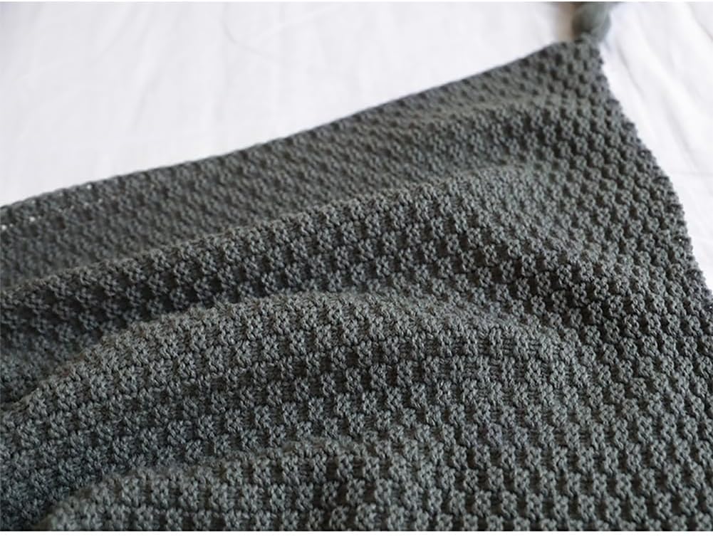 Close-up view of the knitted texture of the dark grey blanket, showing the intricate pattern.