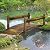 Outsunny 7.5' Wooden Garden Bridge with Planters, Stained Finish Arc Footbridge with Safety Railings for Backyard, Pond Stream, Stained Wood