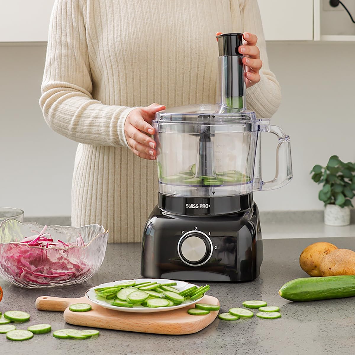 Person assembling the food processor and slicing cucumbers