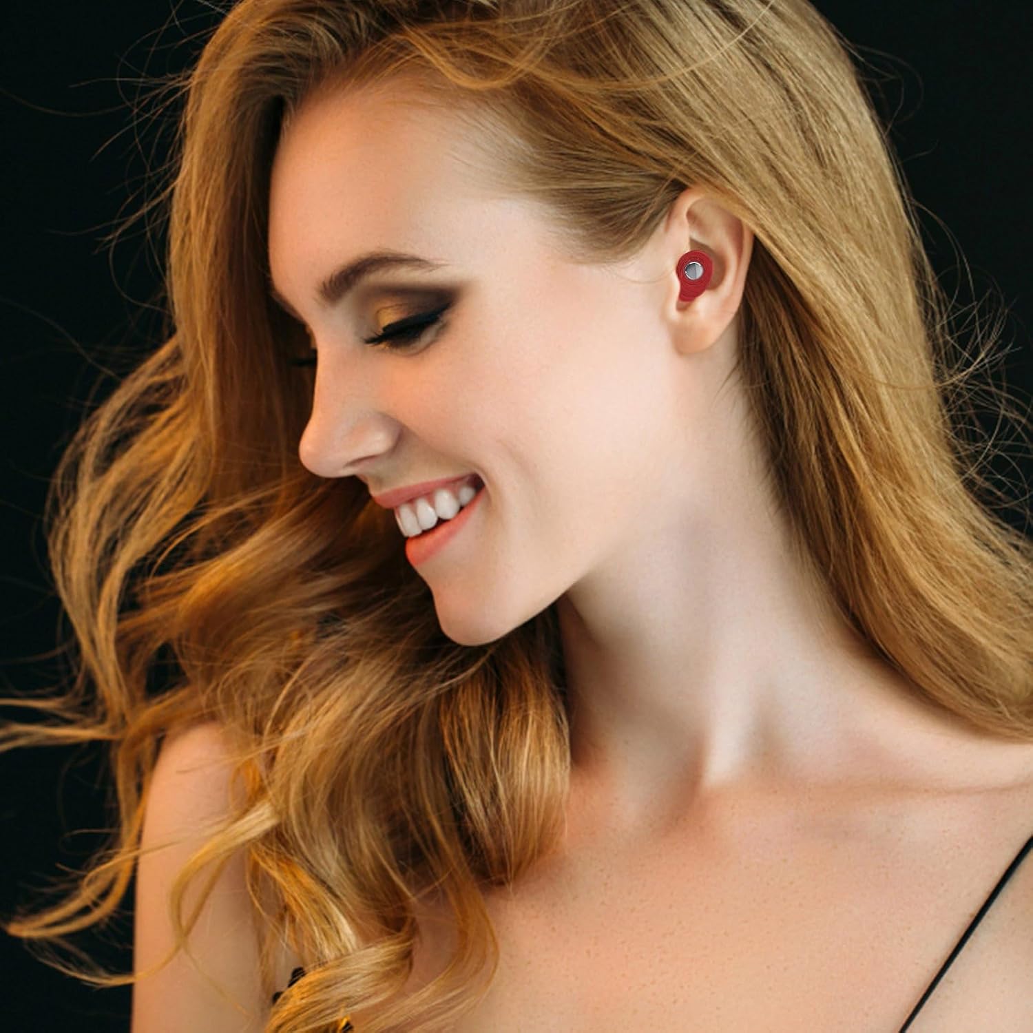 A woman smiling and wearing the red K08 earbud in her right ear.
