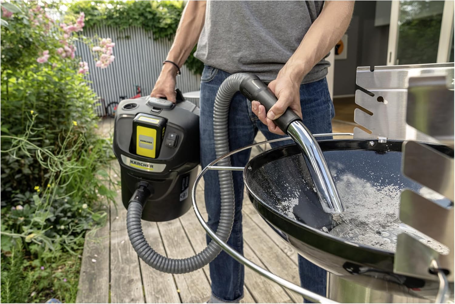 Man cleaning a barbecue grill with Kärcher AD 2 ash vacuum