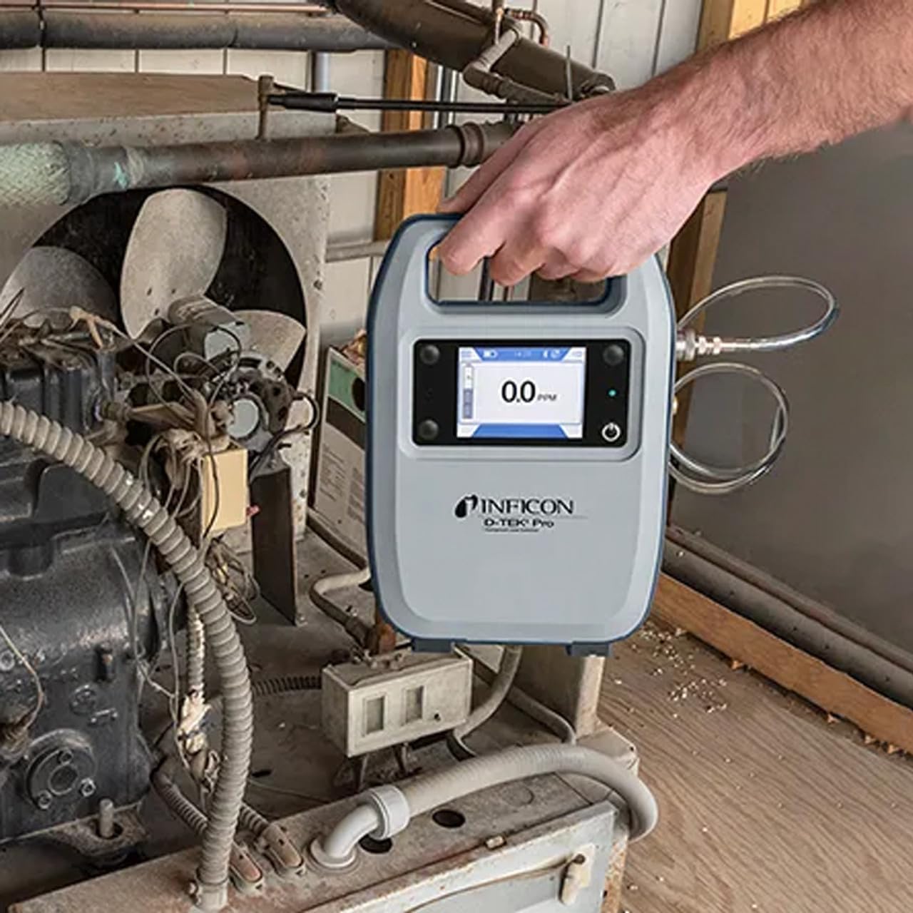 Inficon D-TEK Pro with a smartphone attached, displaying the mobile app interface for leak detection data.