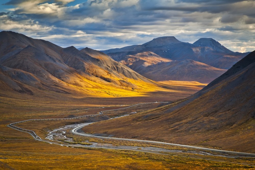 Sunset lighting Brooks Range at Chandalar Shelf, viewed from Atigun Pass tra i Gates of the Arctic National Park & Preserve and Arctic National Wildlife Refuge con Dalton Hwy e taglio pipeline