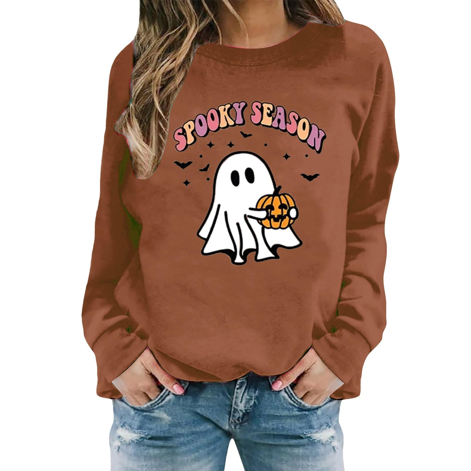 Woman wearing a brown 'Spooky Season' ghost graphic sweatshirt