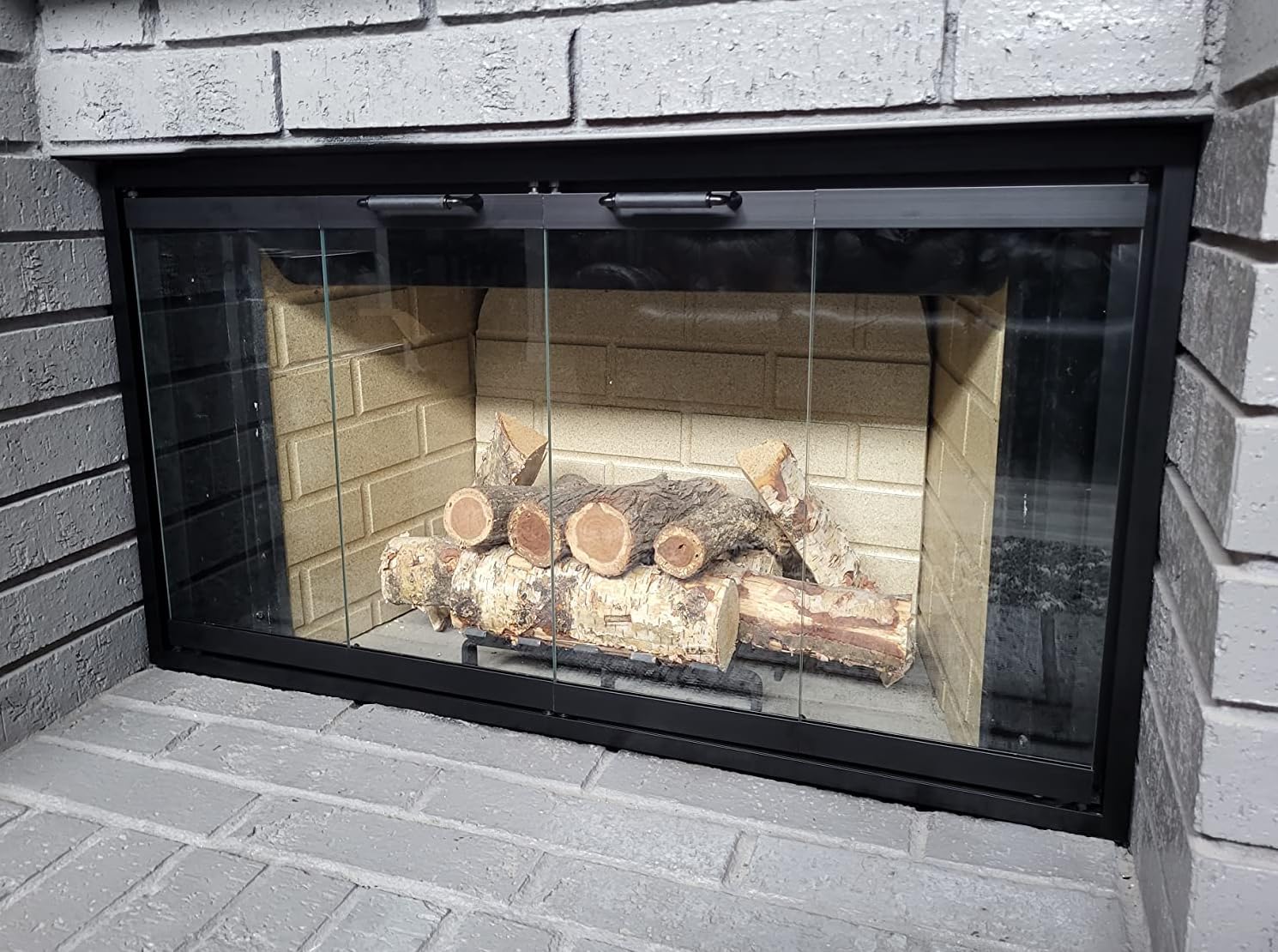 Installed fireplace doors in a brick fireplace