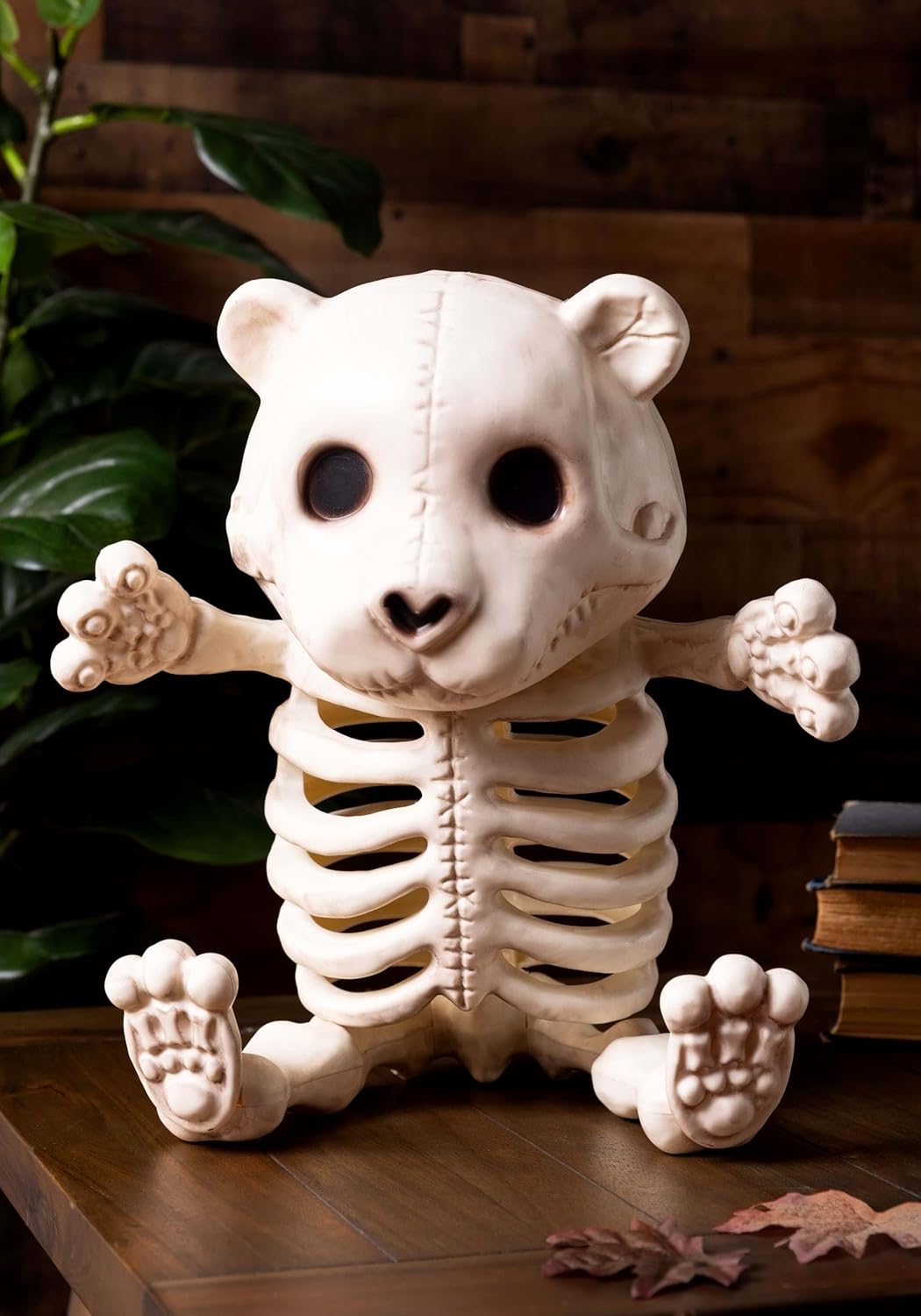 Teddy Bear Skeleton placed on a wooden surface with plants in the background