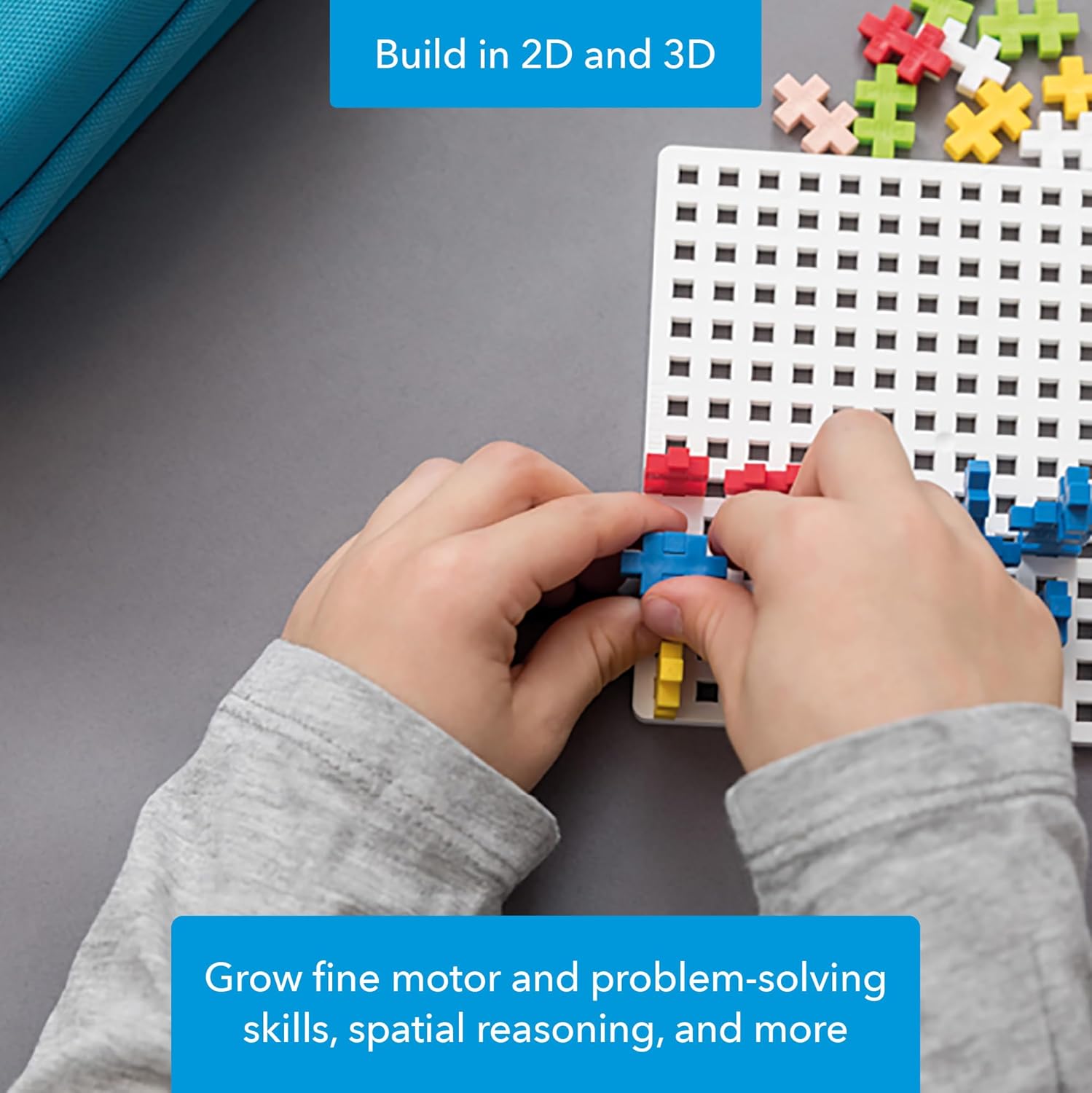 Child's hands building a 2D design on a white baseplate with colorful PLUS PLUS pieces.