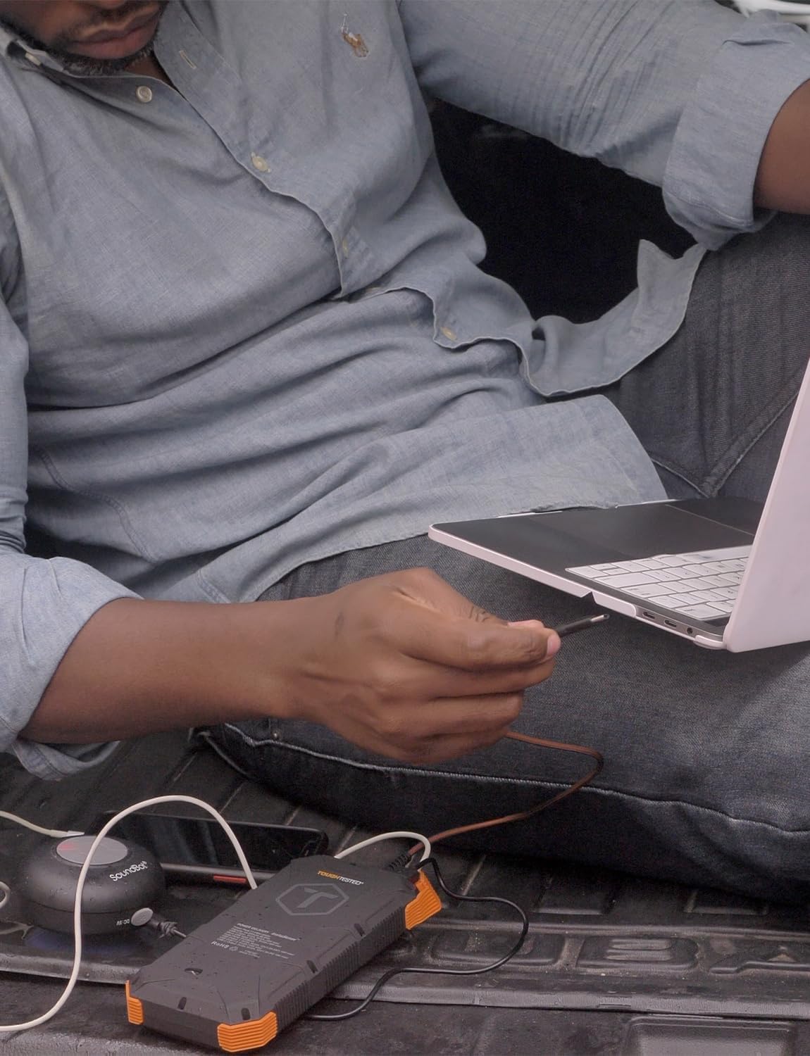 Person charging a laptop with the ToughTested Solar Power Bank