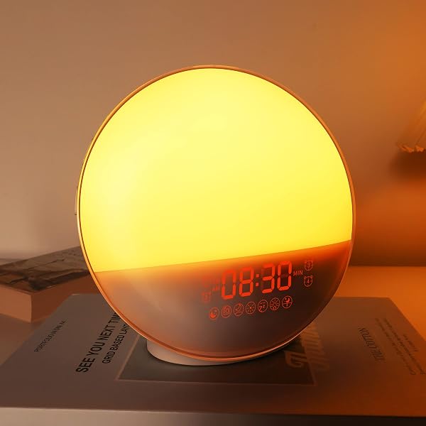 Bedside sunrise alarm clock glowing warmly