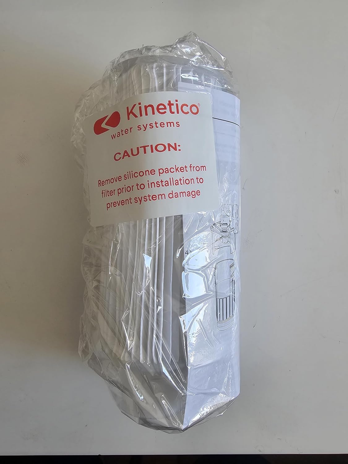 KINETICO 5 Micron 10 inch Pleated Filter Cartridge in its clear plastic packaging with a red caution label.
