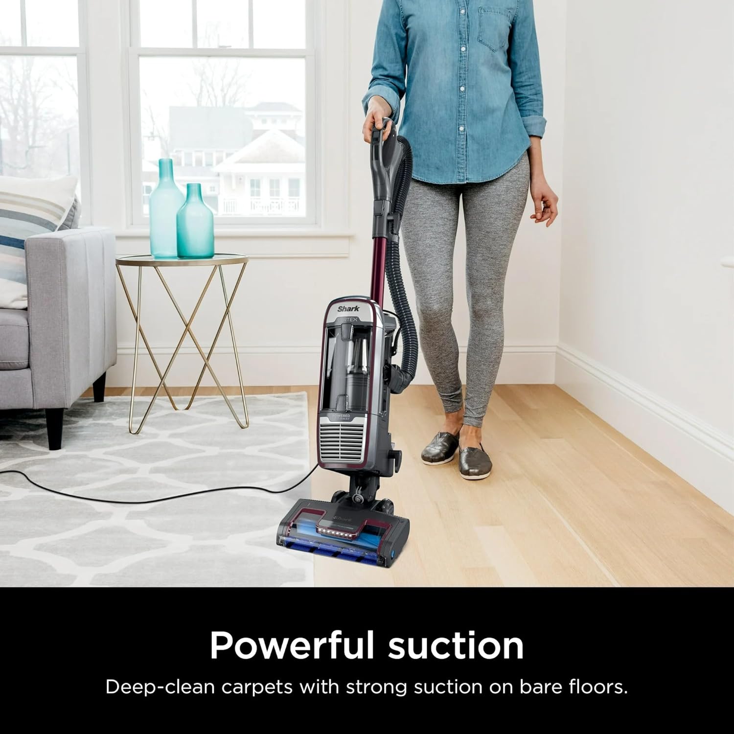 Woman vacuuming a rug with the SHARK Vertex vacuum, illustrating powerful suction