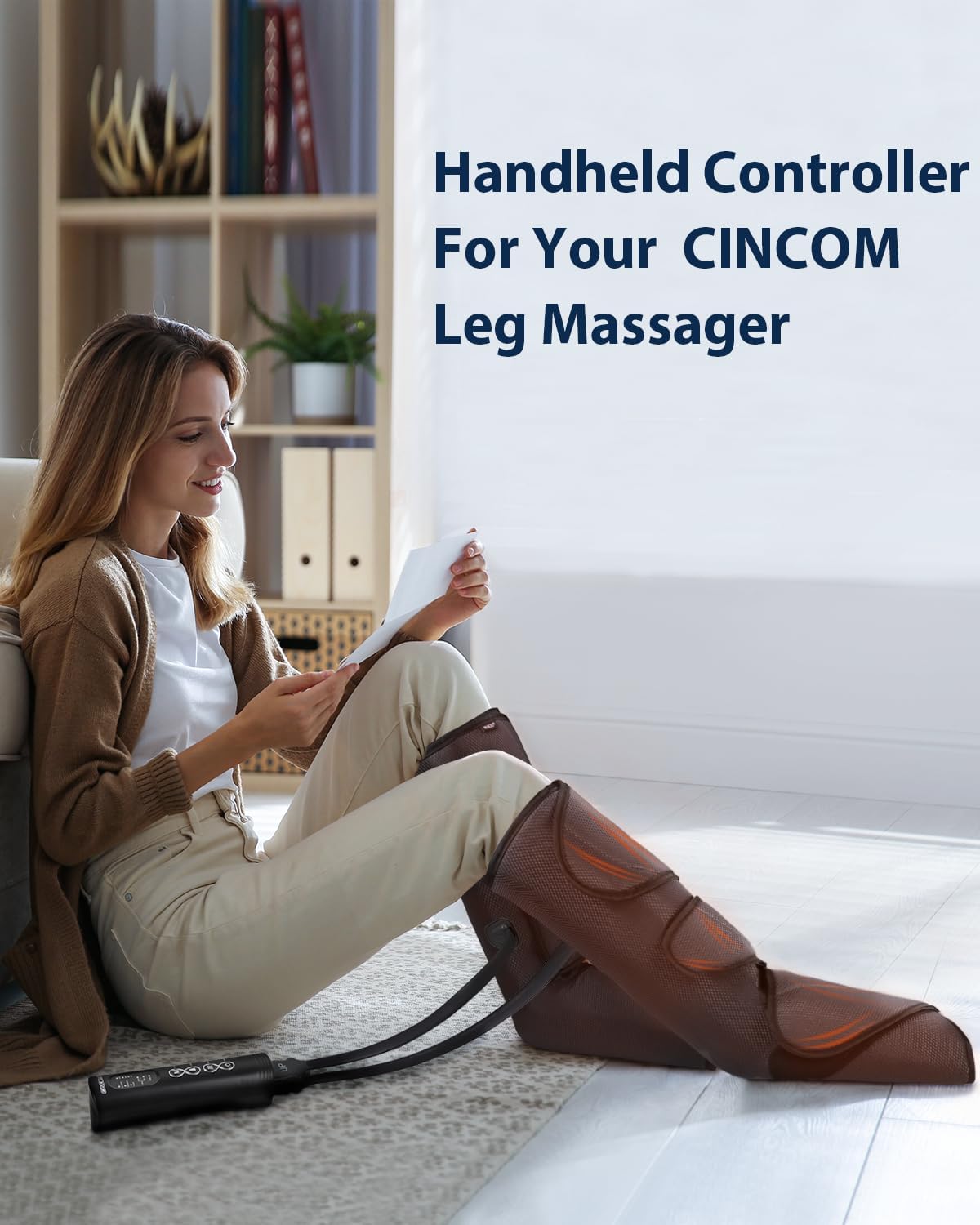 A person sitting on the floor using a CINCOM leg massager with the handheld controller. The controller is placed on the floor next to the user.