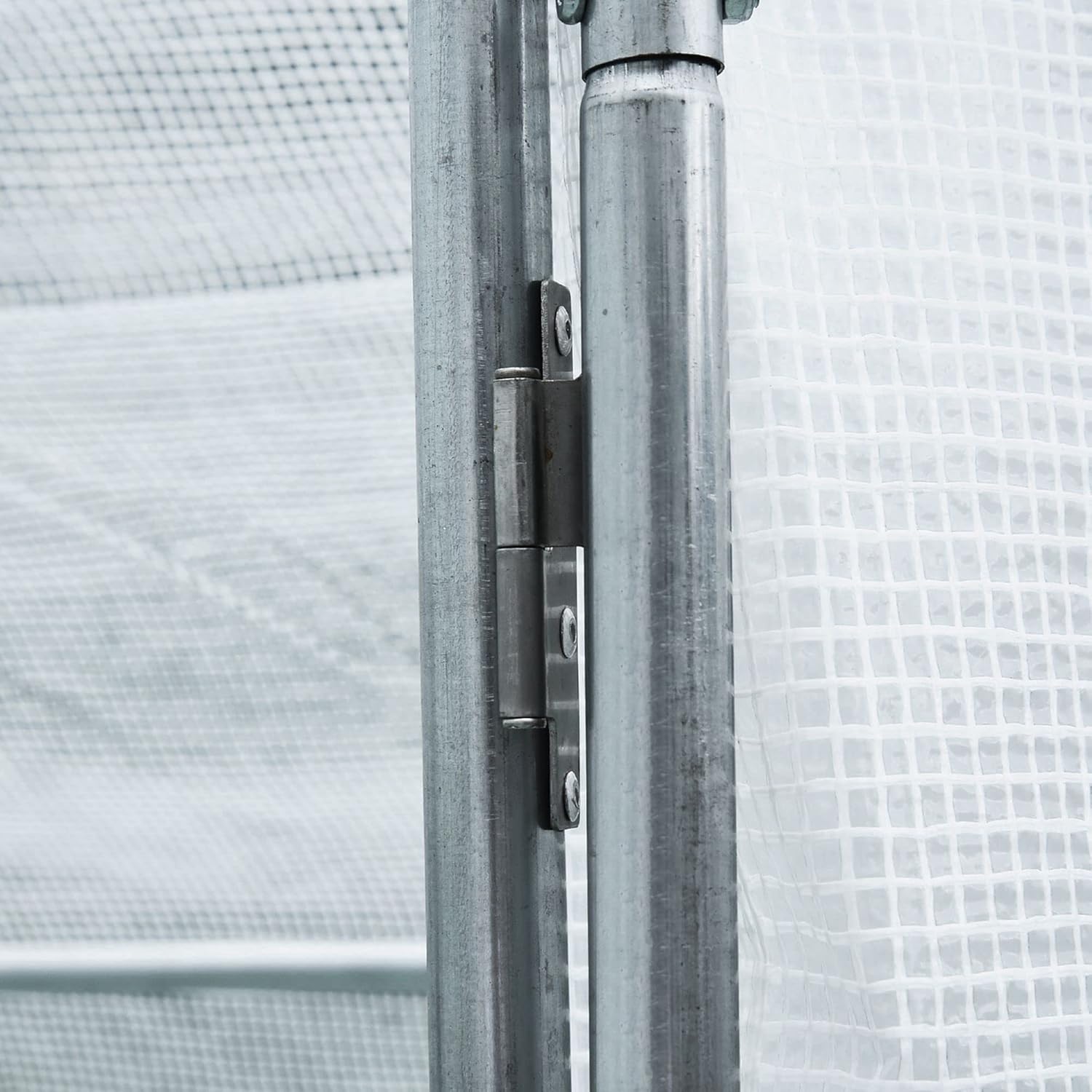 Close-up of a door hinge on the greenhouse frame.