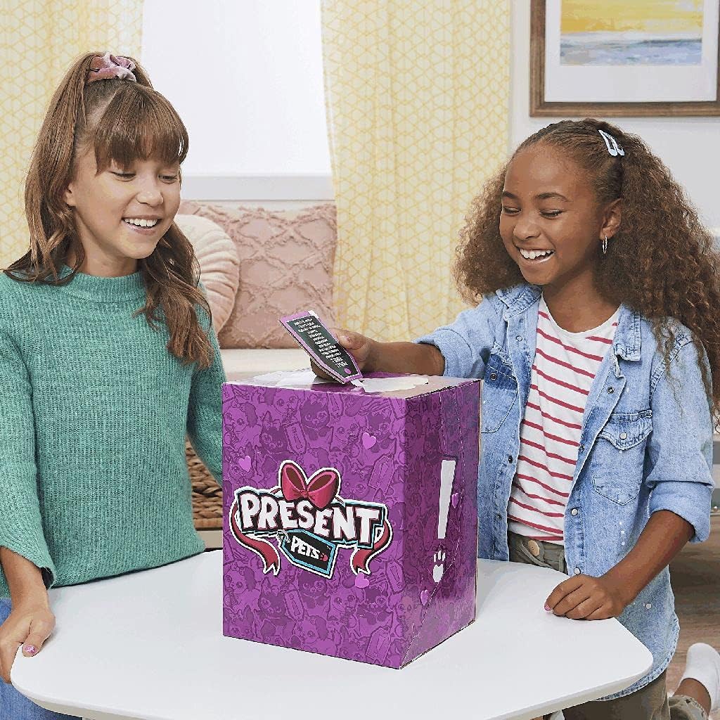 Two children smiling and interacting with the Present Pets box, one pulling a tab.