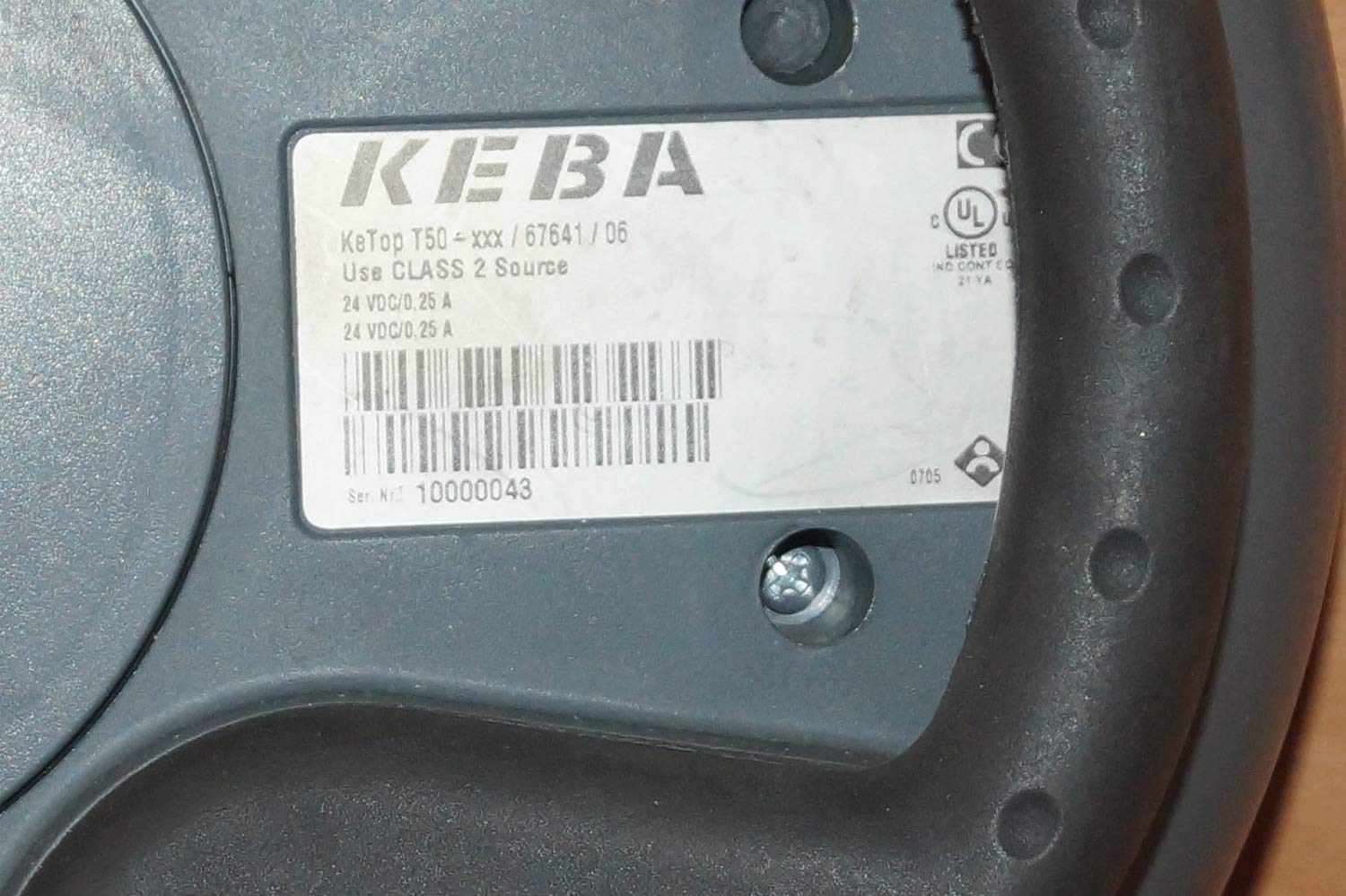 Close-up of the label on the back of the Keba KeTop T50-xxx/67641/06, showing model number, electrical specifications (24 VDC/0.25 A), and serial number.