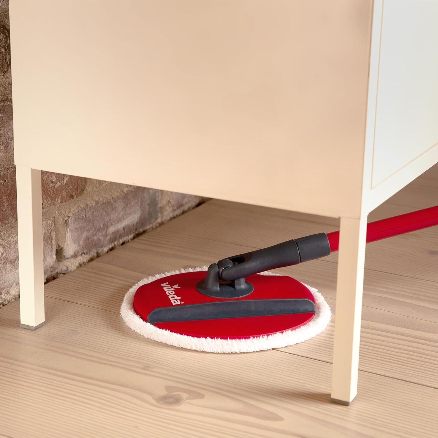 Vileda Spin & Clean mop cleaning under a piece of furniture.