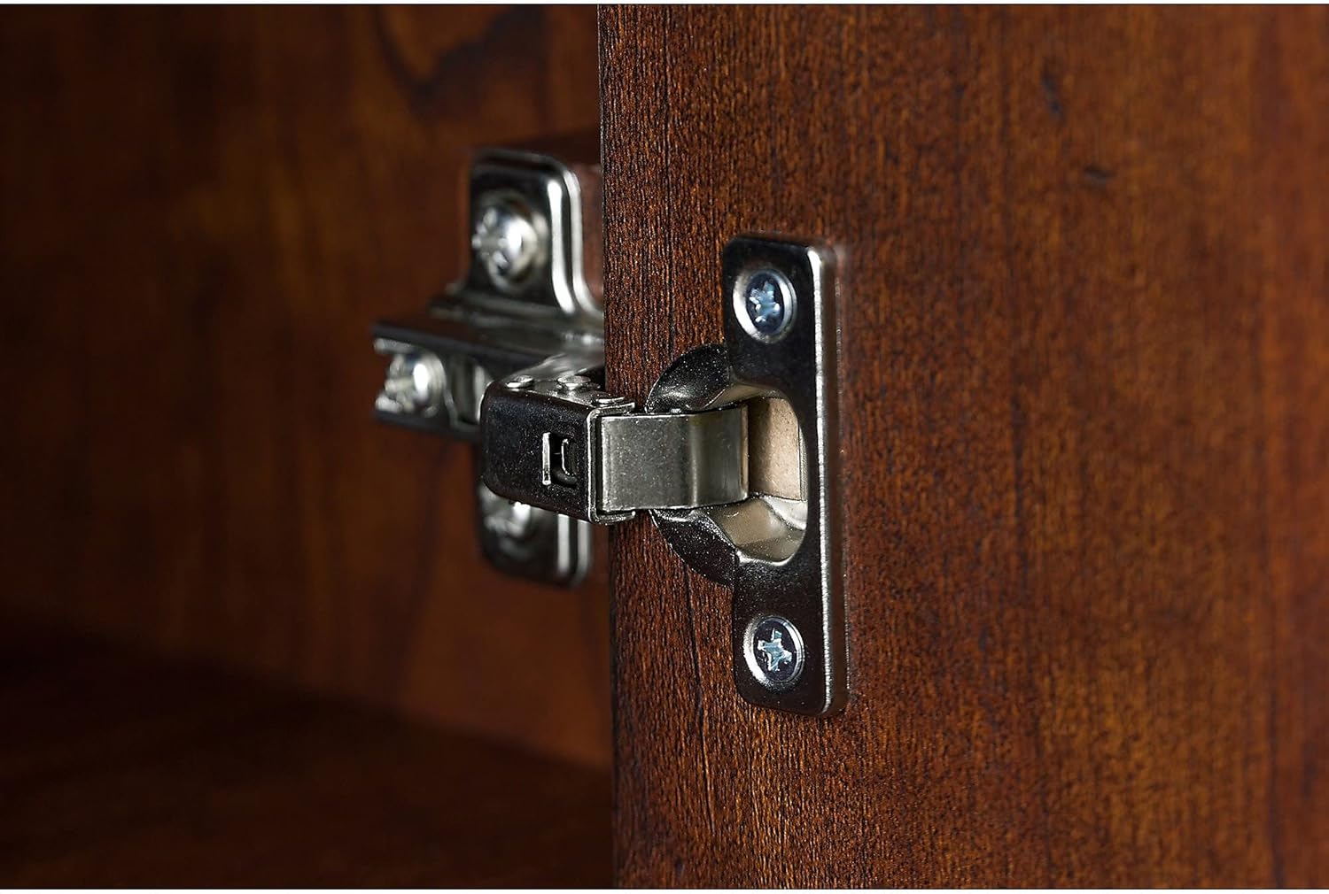 Close-up of a Euro-style hinge on the inside of a hutch cabinet door.