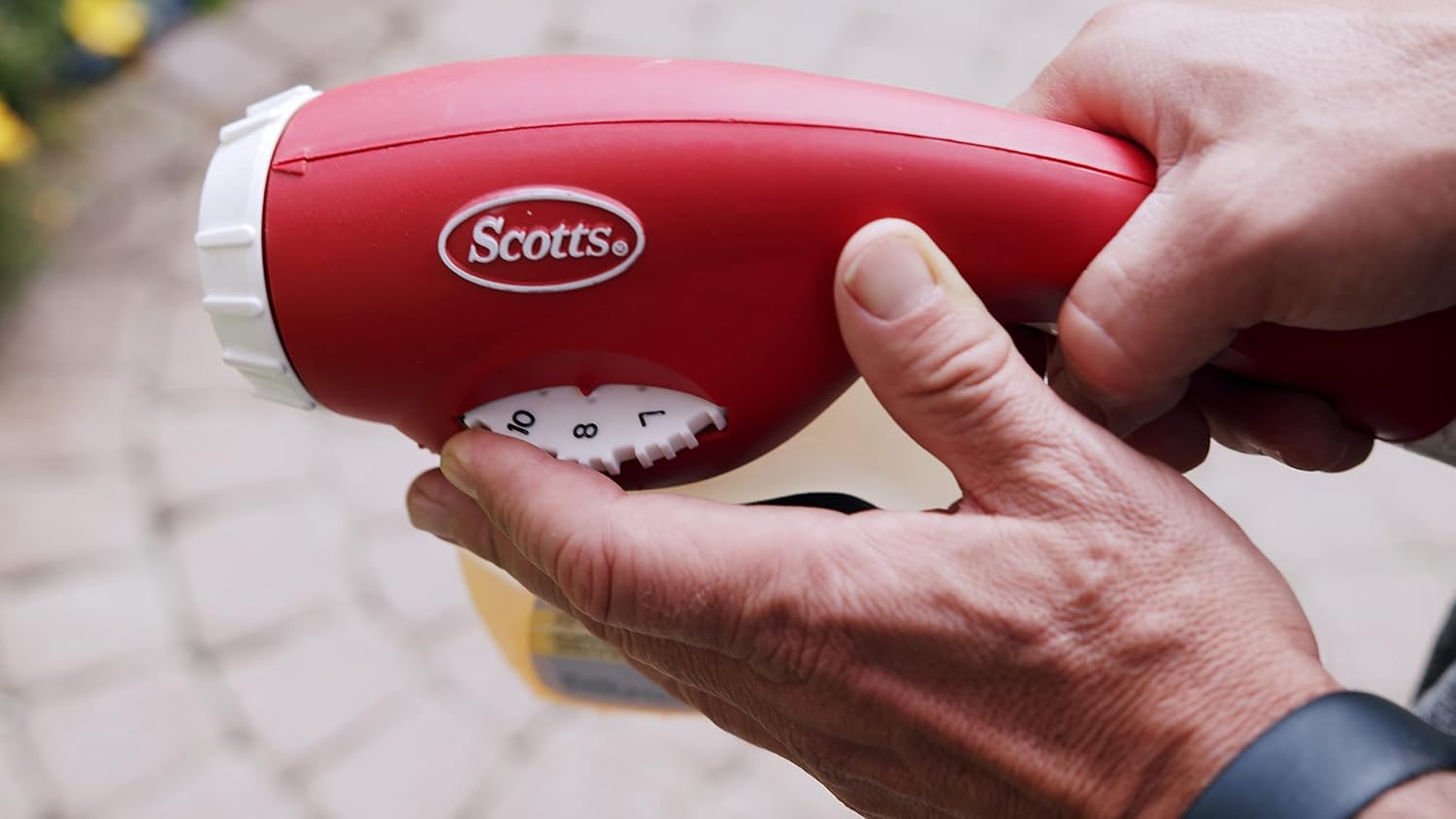 Hand adjusting the dilution dial on the sprayer