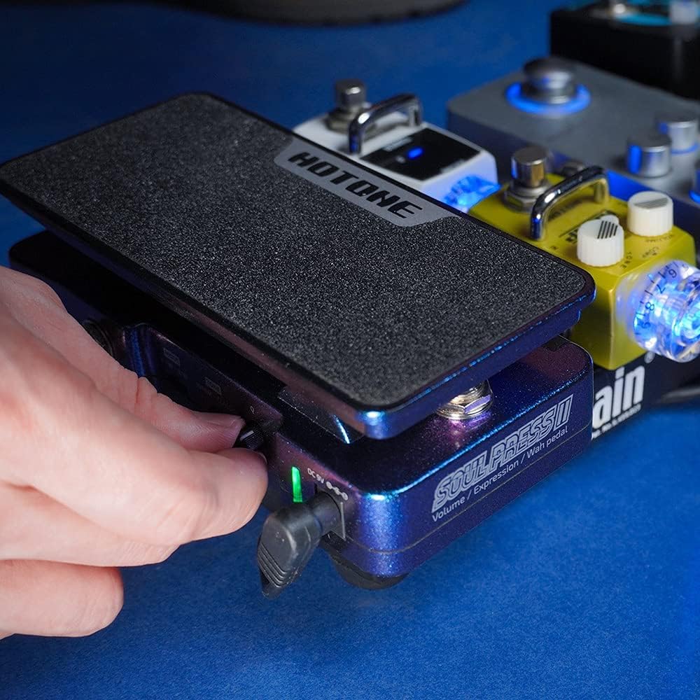 A hand adjusting a knob on the side of the Soul Press II pedal, demonstrating the ease of control.
