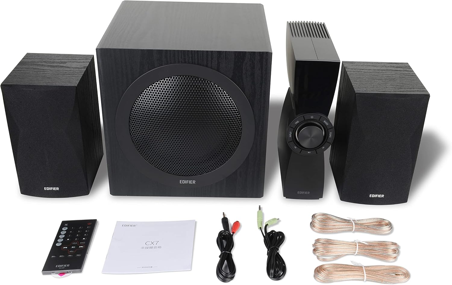 All components of the Edifier CX7 system laid out, including the subwoofer, two satellite speakers, control unit, remote control, cables, and user manual.