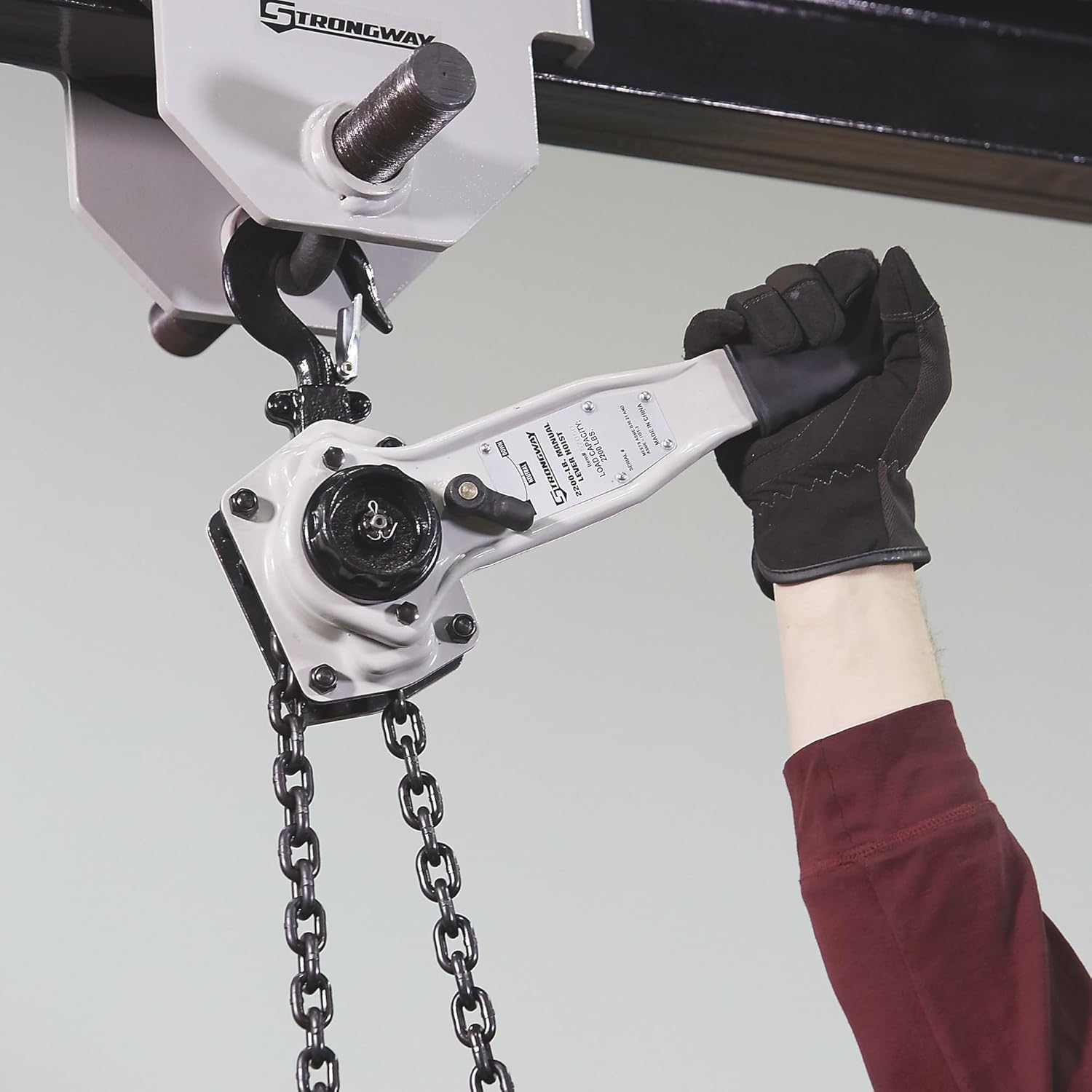 Person operating the lever handle of the Strongway hoist.