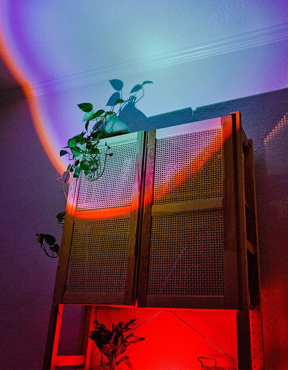 Rainbow light projected onto a wall and cabinet, creating a colorful ambiance.
