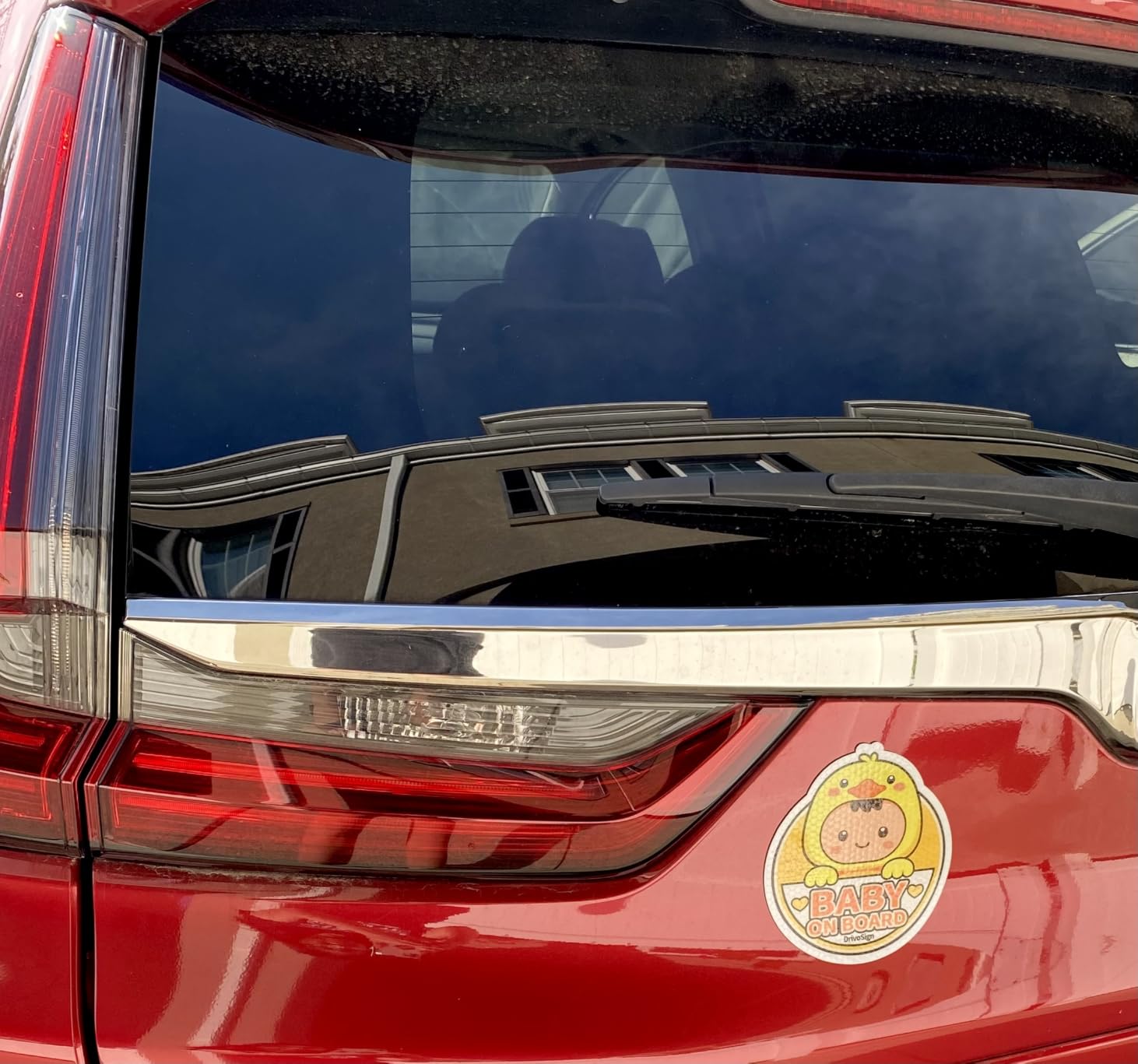 Amazon customer photo of a DrivoSign Baby on Board reflective magnet installed on a red SUV