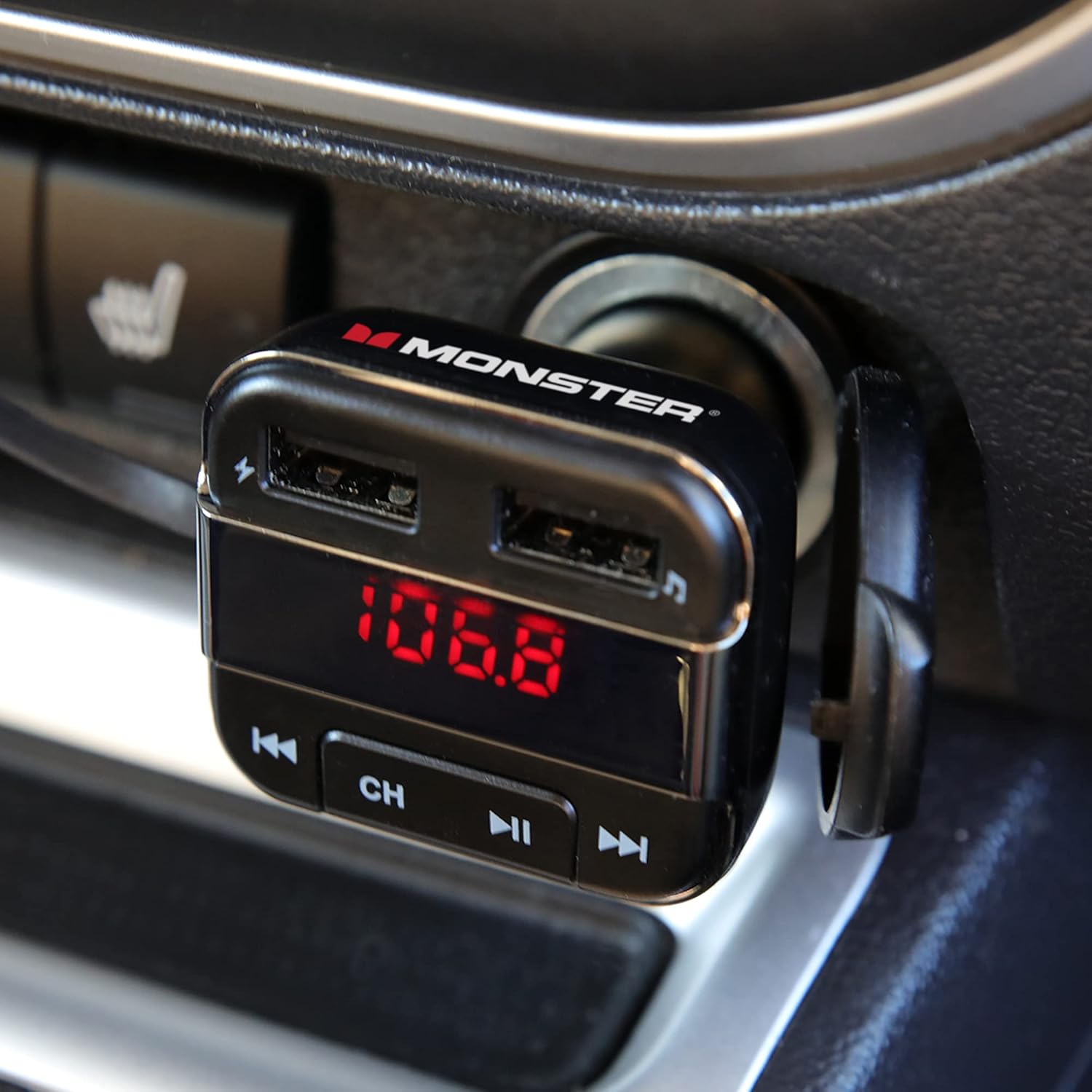 Monster Bluetooth FM Transmitter plugged into a car's power outlet, displaying '106.8'.