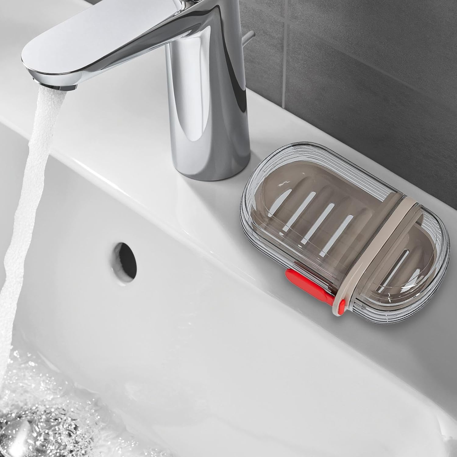 The soap container placed next to a sink with running water, demonstrating its use in a bathroom setting.