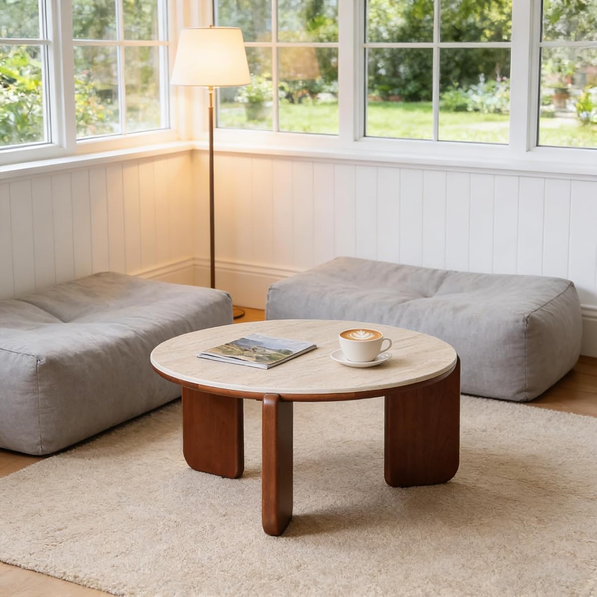 A round coffee table with a real travertine stone top and slim metal base
