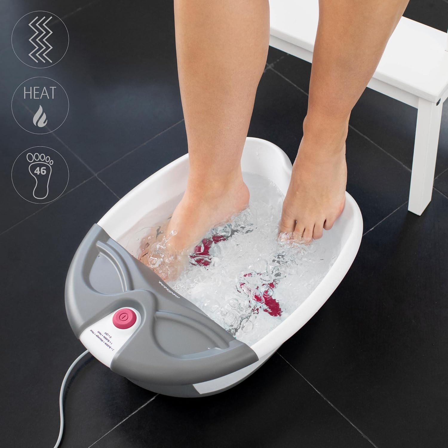 User's feet immersed in the MEDISANA FS 300 Foot Spa, demonstrating the bubbling massage function.