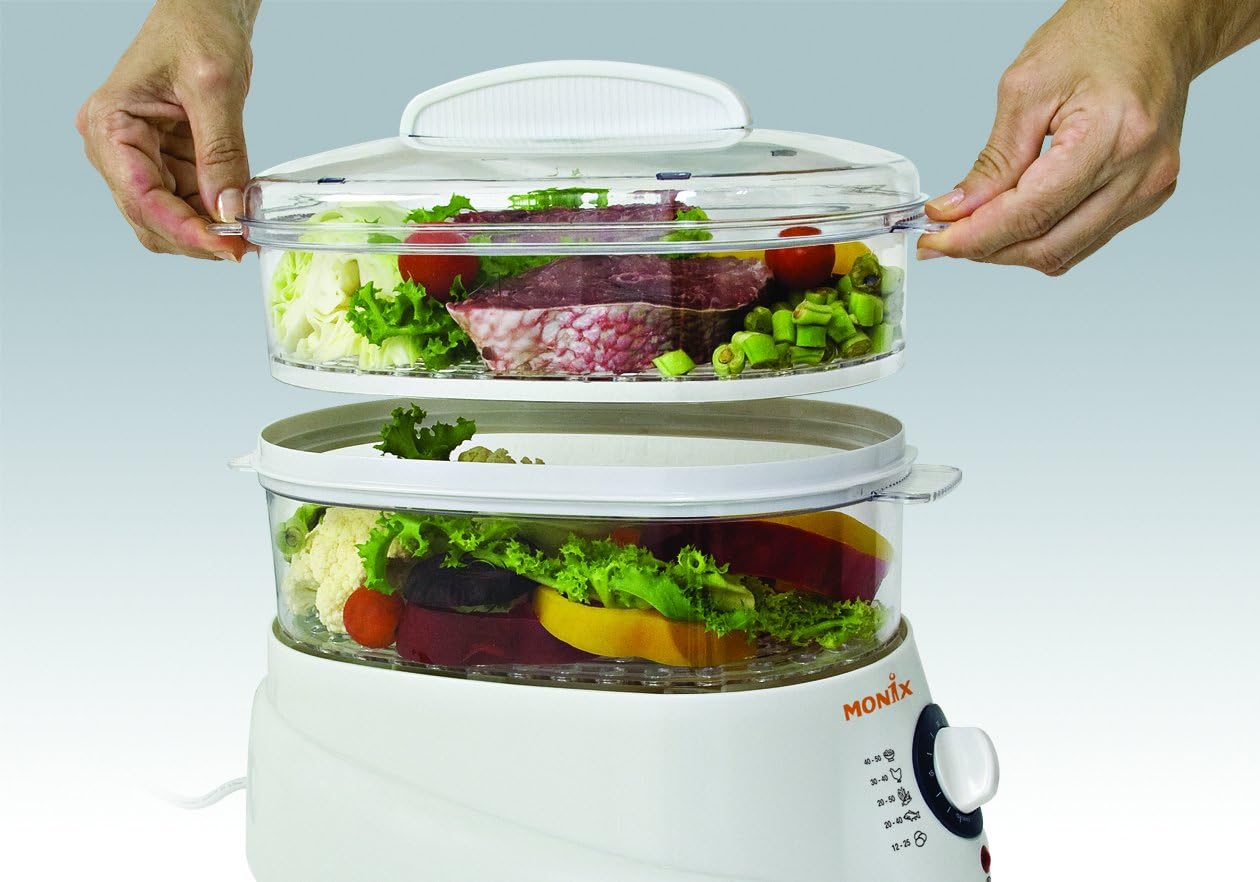 Hands placing a steam basket onto the Monix Salutemax Food Steamer