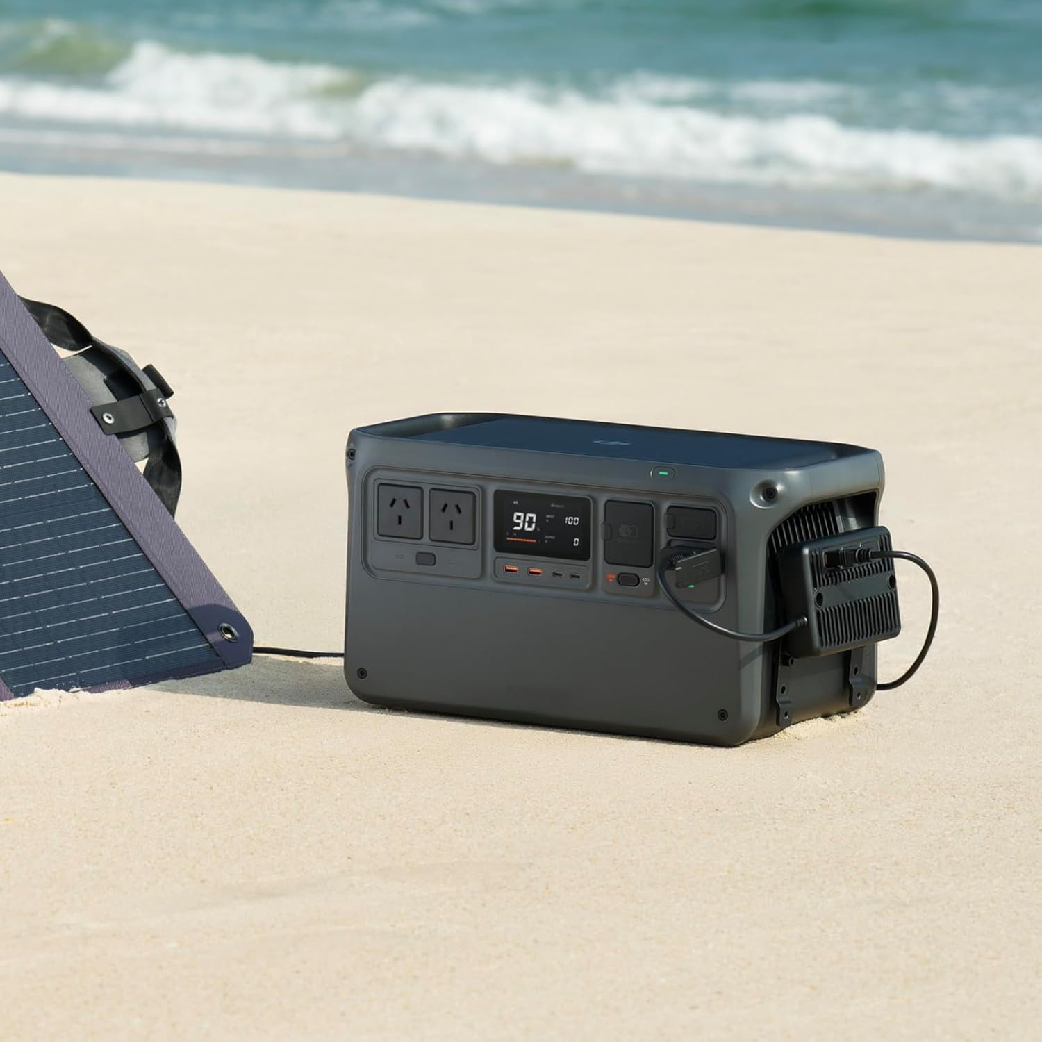 DJI Power Solar Panel Adapter Module attached to a DJI Power station, connected to a solar panel on a beach