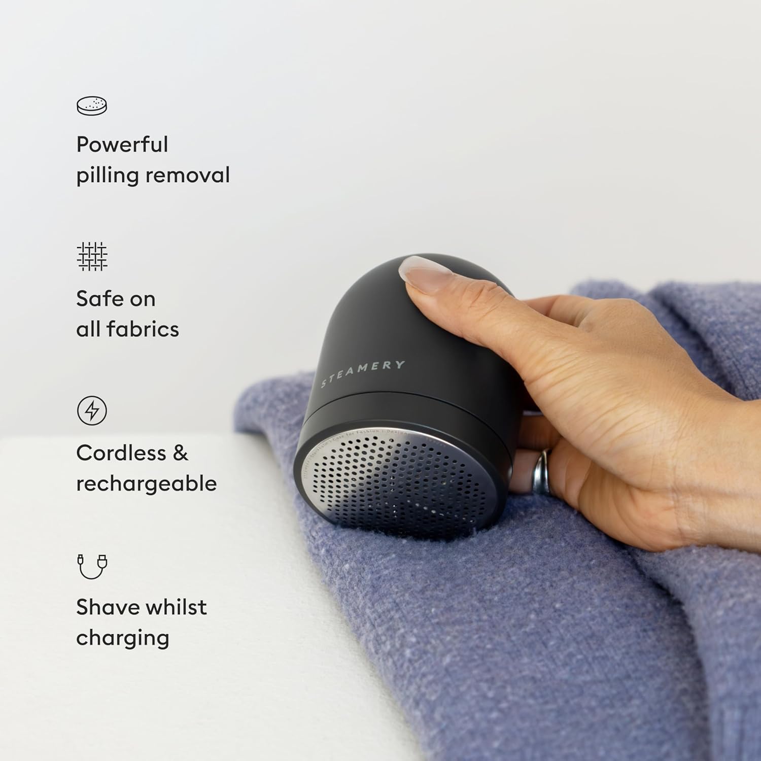 Steamery Fabric Shaver Pilo 2 in use on a purple sweater, highlighting its powerful pilling removal, safety on all fabrics, cordless design, and ability to shave while charging.