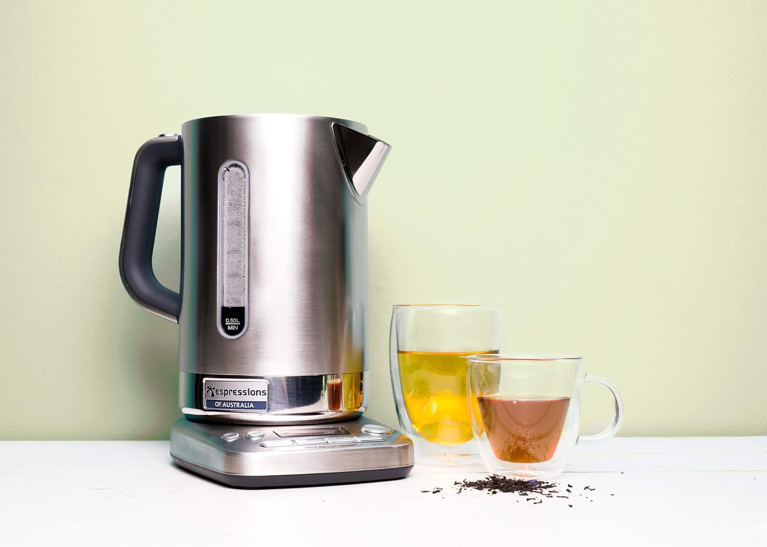 Espressions Smart Kettle on a counter with two glasses of tea, illustrating its use for various beverages.