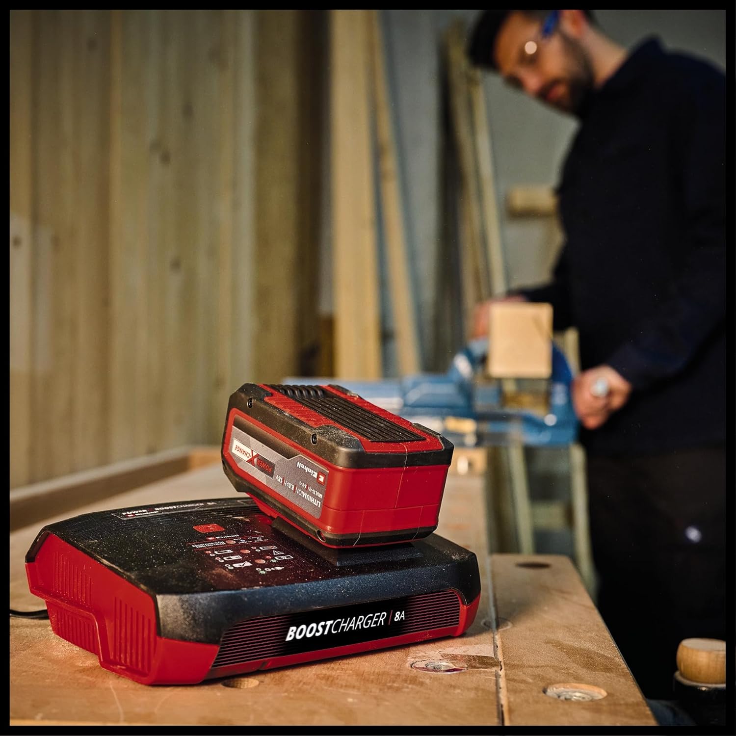 เครื่องชาร์จ Einhell Power X-Boostcharger 8A พร้อมแบตเตอรี่บนโต๊ะทำงาน