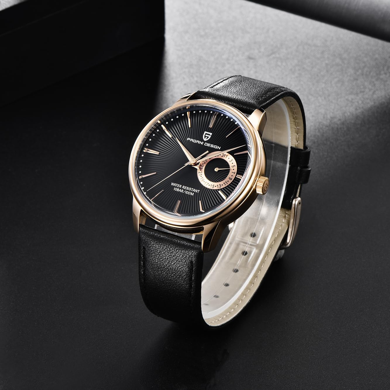 Close-up of the Pagani Design PD1654 watch face, showing the black dial, gold-tone hands, and date display.