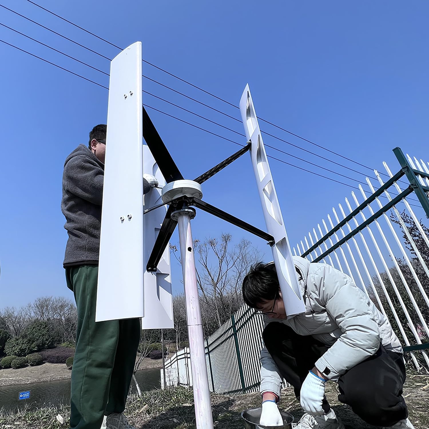 FLTXNY POWER vertical axis wind turbine installed in an outdoor setting near water