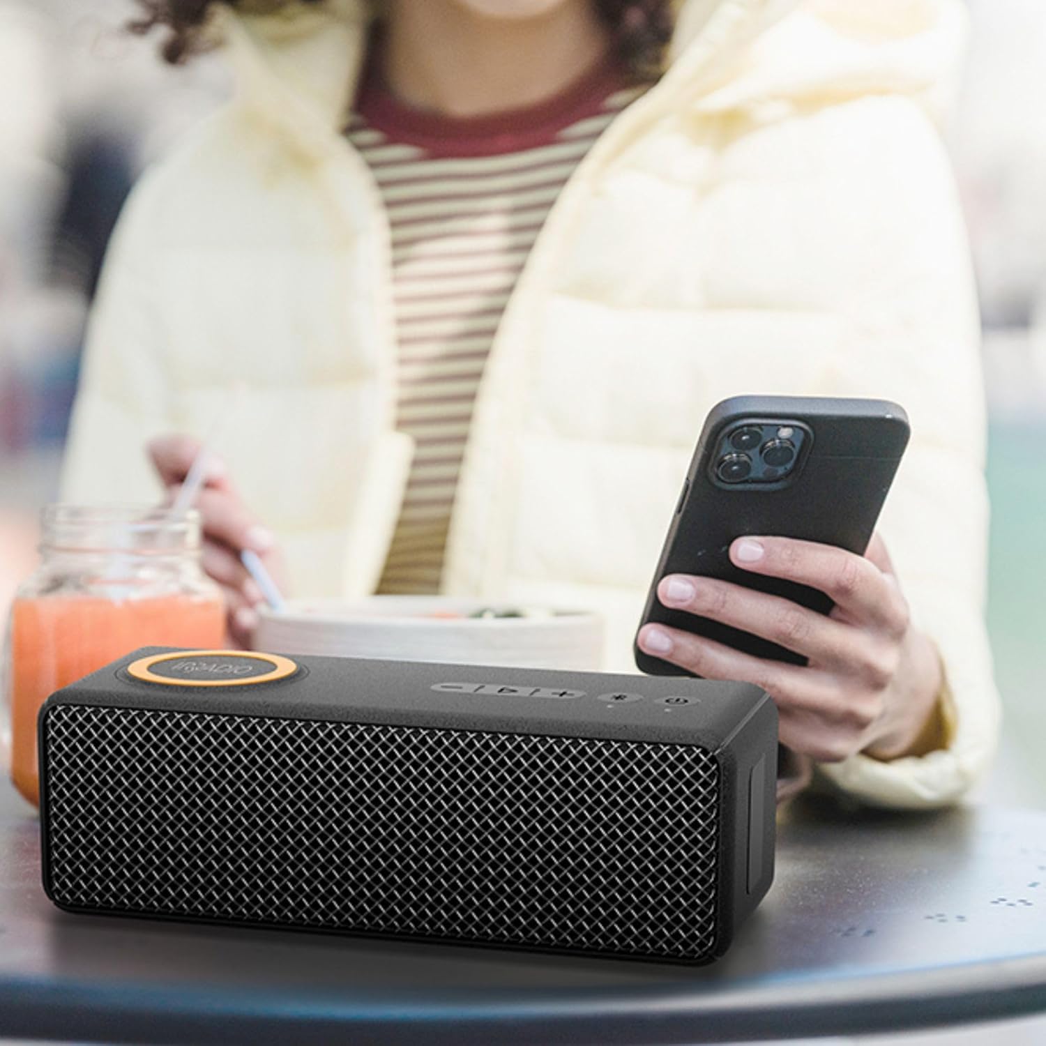 IRRADIO IR-M9 speaker wirelessly charging a smartphone