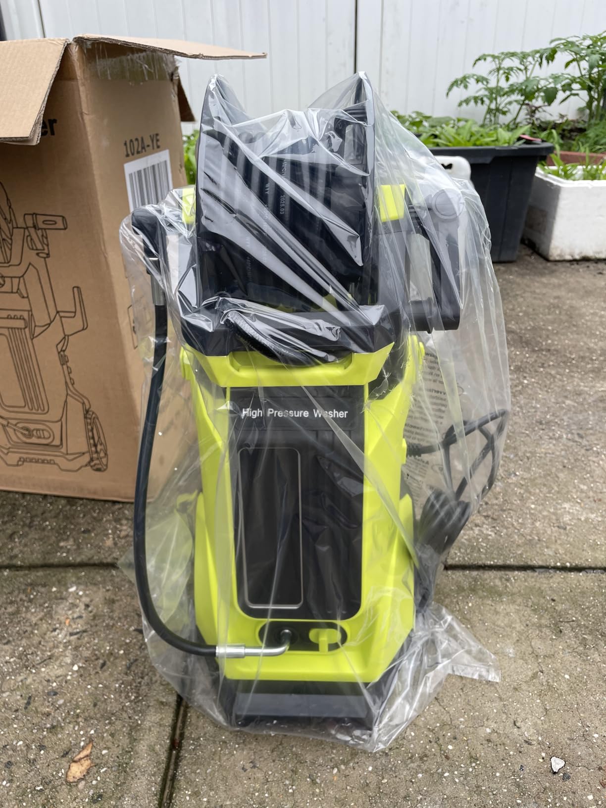 Pressure washer in use, cleaning a concrete patio