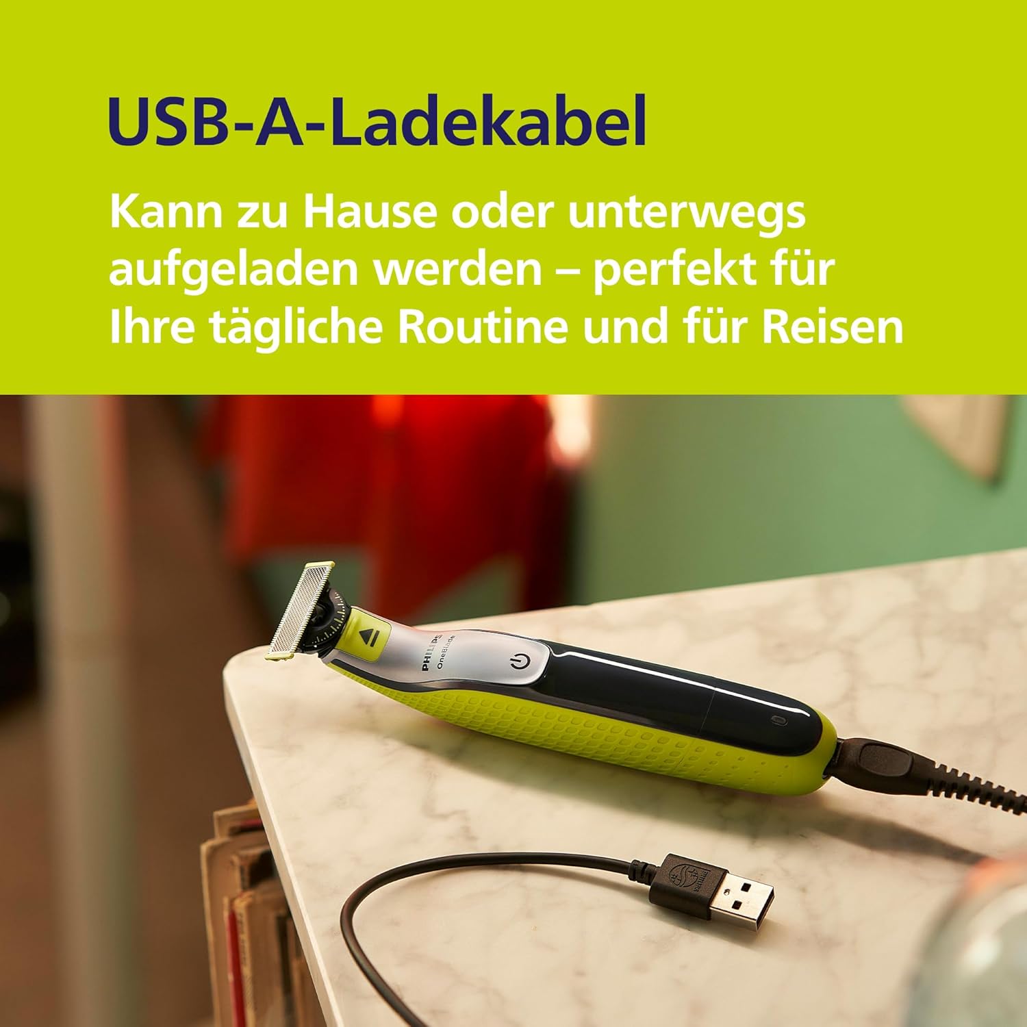 Philips OneBlade 360 connected to a USB-A charging cable on a table.
