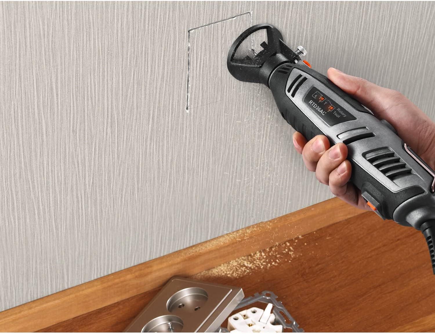 Rotary tool with cutting guide attachment being used to cut a rectangular opening in a wall.