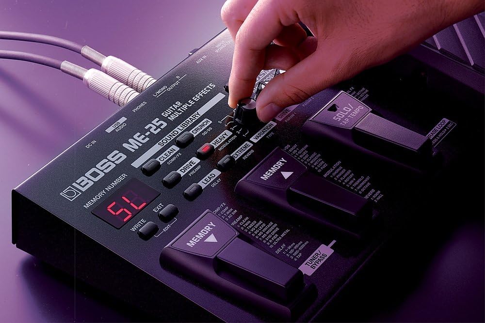Hand adjusting a knob on the BOSS ME-25 with a wider view ny pedal