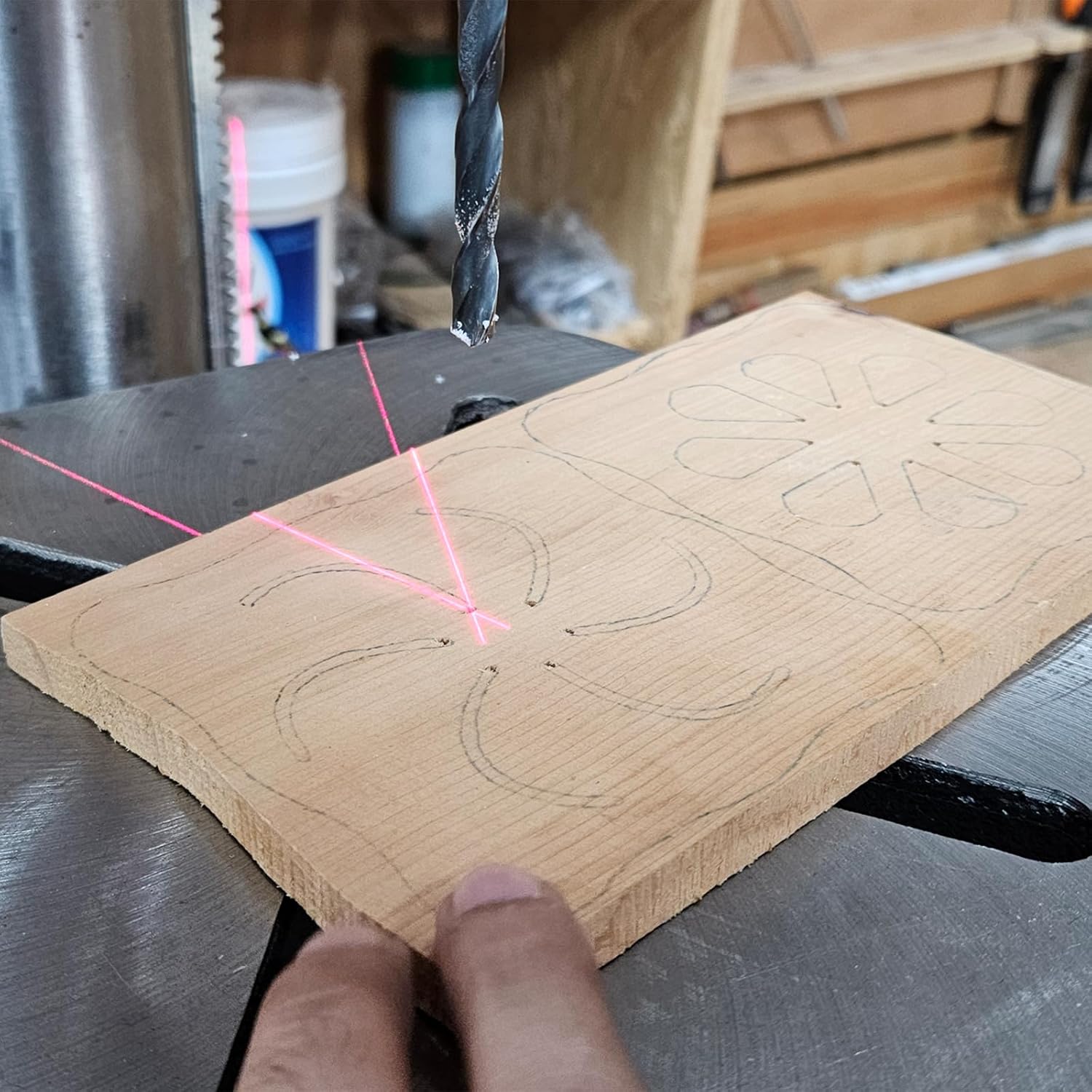 Laser crosshairs projected onto a wooden workpiece for precise drilling